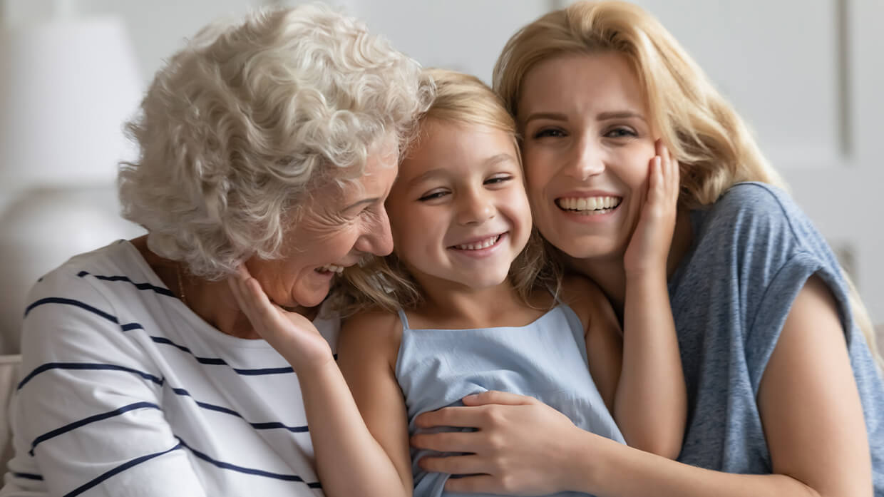 Jeune fille souriante entourée de sa mère et de sa grand-mère